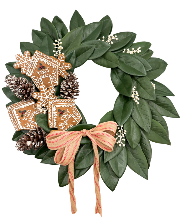 Decorative wreath with green leaves, gingerbread cookies, pinecones, and a brown ribbon on a white background.